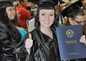 graduate with thumbs up, holding diploma