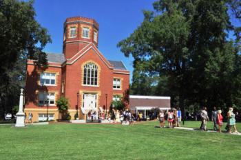 students by a brick building with limestone college banner