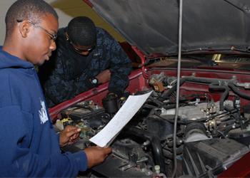 two people working on car engine