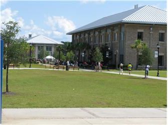 students on campus green with a building