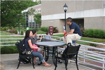 two people chatting at a campus outdoor table