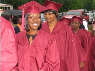 graduates in maroon gowns smiling