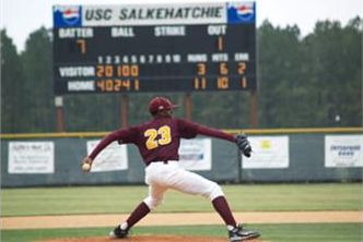 baseball player pitching with scoreboard in background