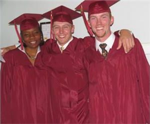 three graduates in maroon with arms around each other