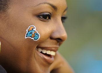 woman with team logo on cheek smiling