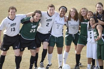 soccer team posing with a ball on the field