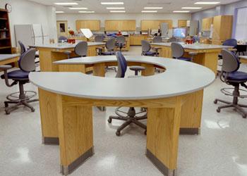 empty classroom with circular tables and rolling chairs