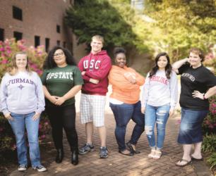 group of students wearing college sweatshirts smiling