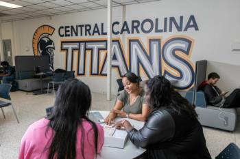 students at a lounge with 'central carolina titans' wall decor