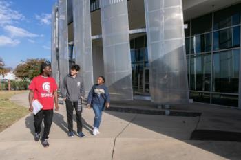 students walking outside a modern campus building