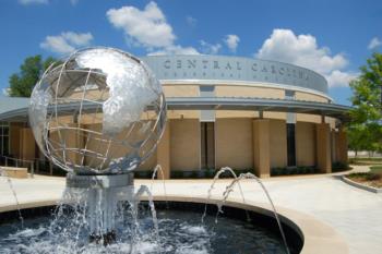 globe fountain in front of modern campus building