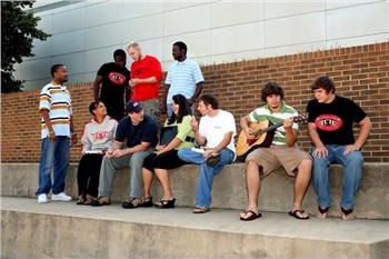 students sitting on steps outside a building