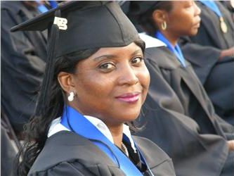 graduate in cap and gown smiling