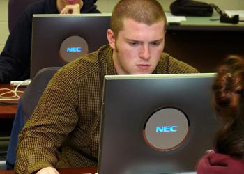 student studying on a laptop in a computer lab