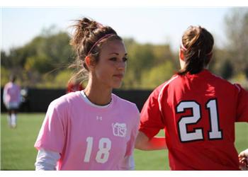 two soccer players on the field, one facing camera