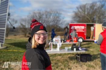 student with beanie near a field project with 'AP Austin Peay State University'