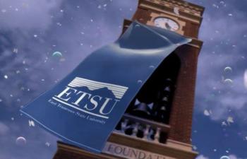 'ETSU' billboard with snow and clock tower