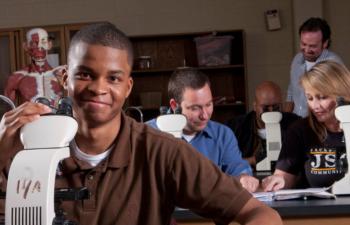 student with a microscope in a lab