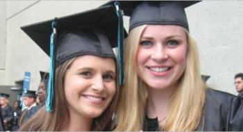 two graduates in caps and gowns smiling