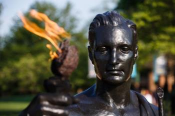 close-up of a statue's face with a flame