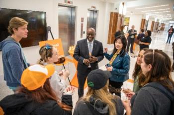 group interacting with person in orange cap