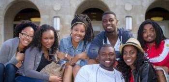 group of students smiling in front of building