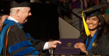 graduation handshake and smiling student