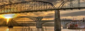 sunrise behind bridges over river