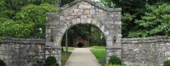 stone archway leading to campus pathway