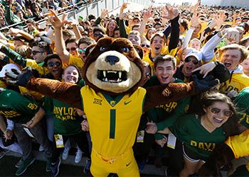 mascot with arms up in front of cheering students