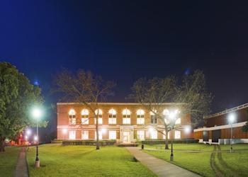 nighttime view of a lit academic building