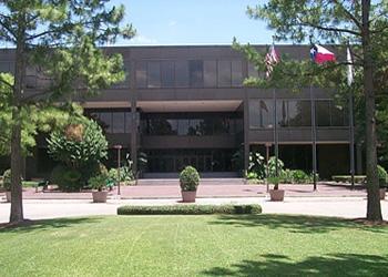 front view of a campus building with green lawn and trees