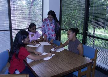 students studying together at a table near windows