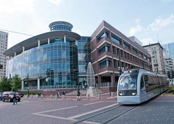 modern campus building with tram passing by