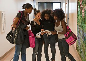 four students studying together in a hallway