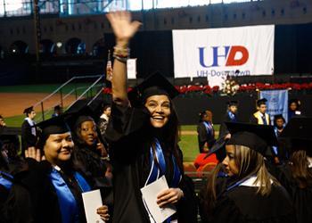 graduates smiling with UHD banner in background