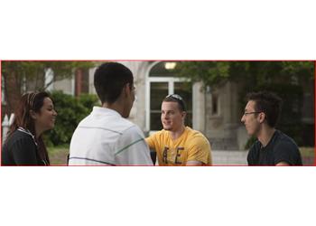 three students conversing in front of a building