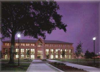 illuminated building at night with pathway and tree