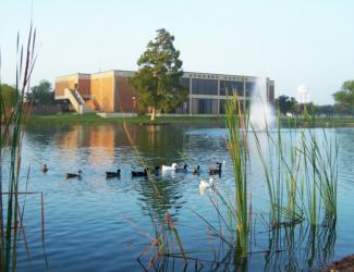 lake with ducks and campus building in background