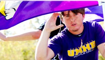 person holding a flag with 'UMHB' letters