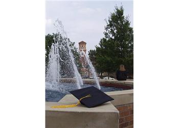 graduation cap by a fountain