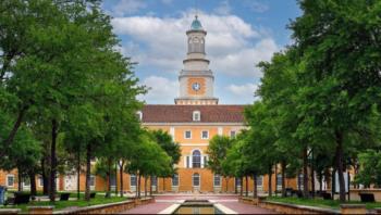 view of a clock tower between green trees