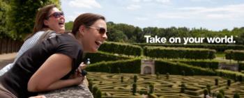 two people laughing with maze sign 'take on your world'