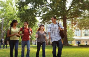 students walking and laughing on campus lawn