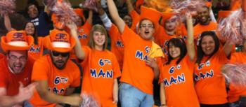 crowd of fans in orange with 'go man' signs