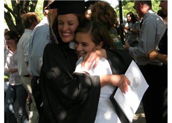 graduates embracing each other at ceremony