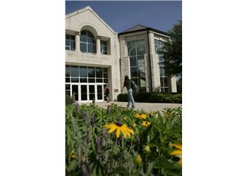 student walking towards a modern campus building