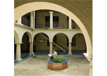 campus courtyard with arches and a student studying