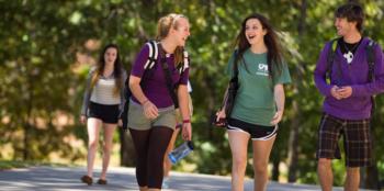 four students walking on campus pathway