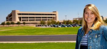 student smiling in front of university parking lot